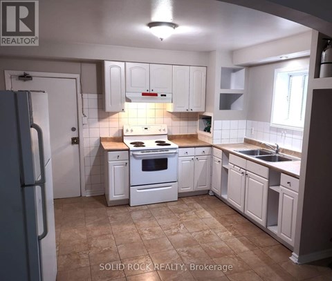 A kitchen with white cabinets and a tiled backsplash.