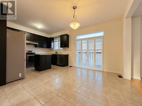 A kitchen with black cabinets and a silver refrigerator.