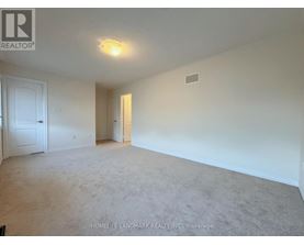 A spacious room with a carpeted floor and white walls.