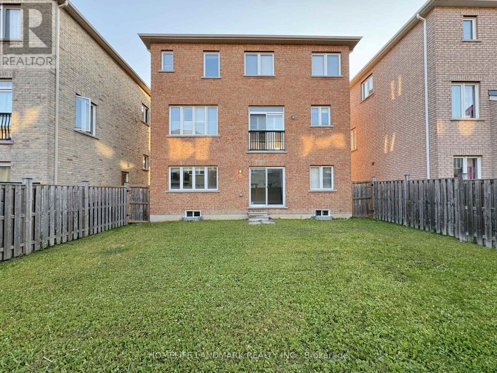 A large grassy yard in front of a brick apartment building.