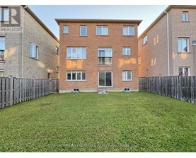 A large grassy yard in front of a brick apartment building.