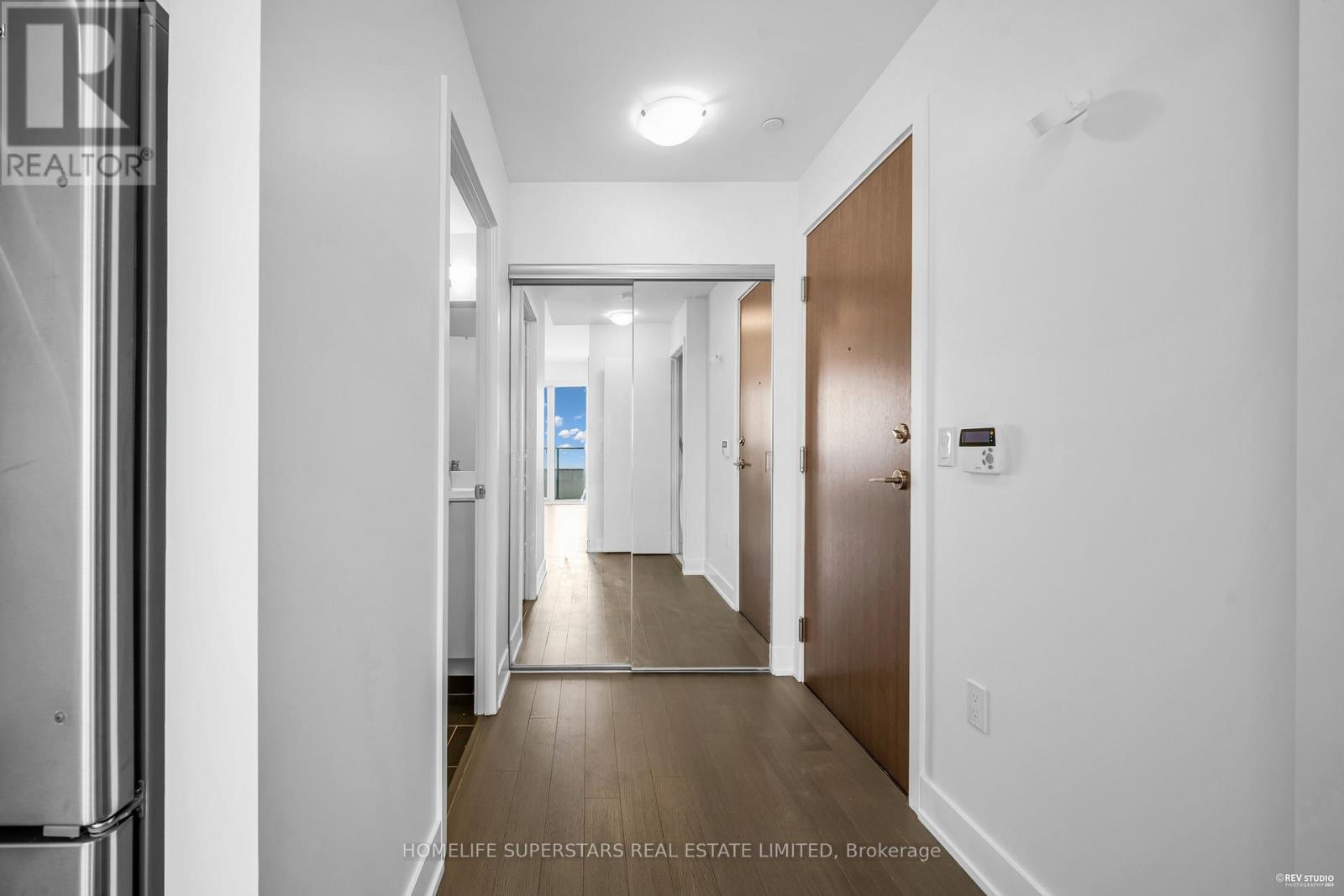 A hallway with a door on the right and a window in the distance.