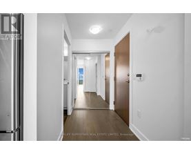 A hallway with a door on the right and a window in the distance.