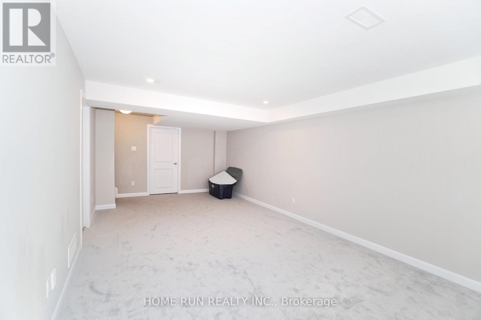 A spacious room with a doorway leading to another room.