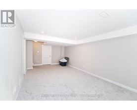 A spacious room with a doorway leading to another room.