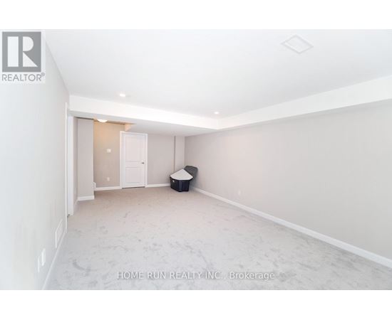 A spacious room with a doorway leading to another room.