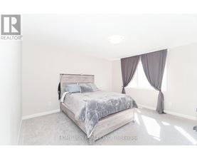 A bedroom with a large bed and a window with curtains.