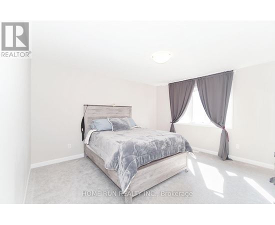 A bedroom with a large bed and a window with curtains.