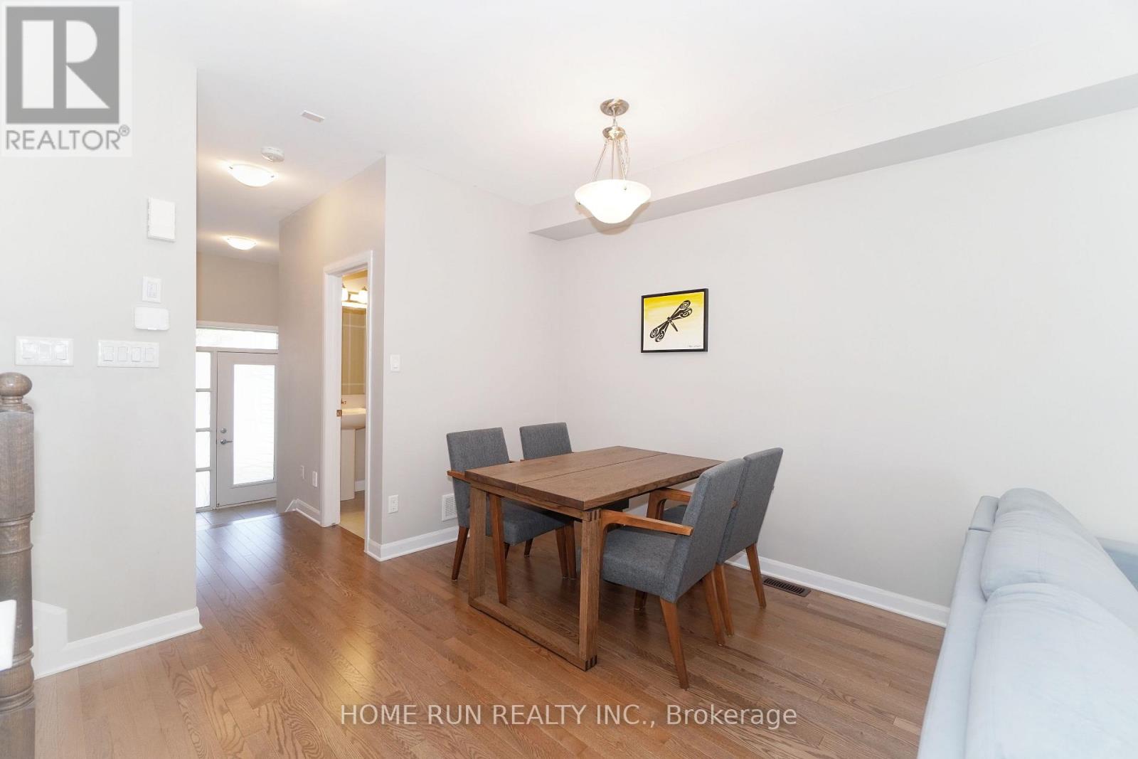 A dining room with a wooden table and chairs.