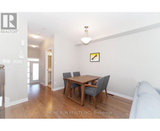 A dining room with a wooden table and chairs.
