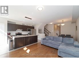 A modern kitchen with a blue couch in the foreground.