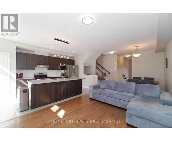 A modern kitchen with a blue couch in the foreground.