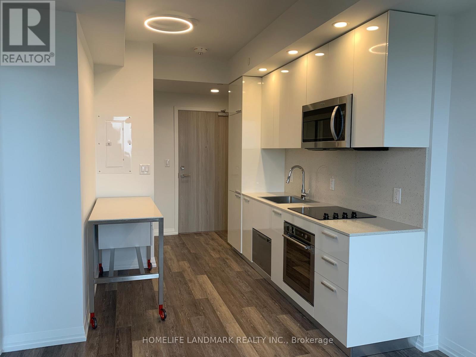 A kitchen with white cabinets and a wooden floor.