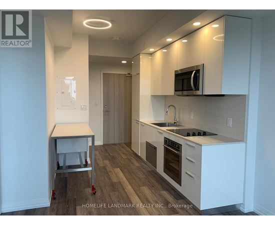 A kitchen with white cabinets and a wooden floor.