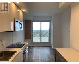 A modern kitchen with a view of the city through the sliding glass doors.