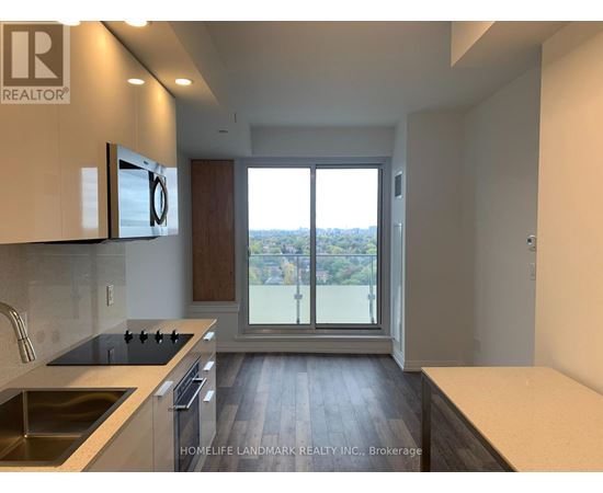 A modern kitchen with a view of the city through the sliding glass doors.