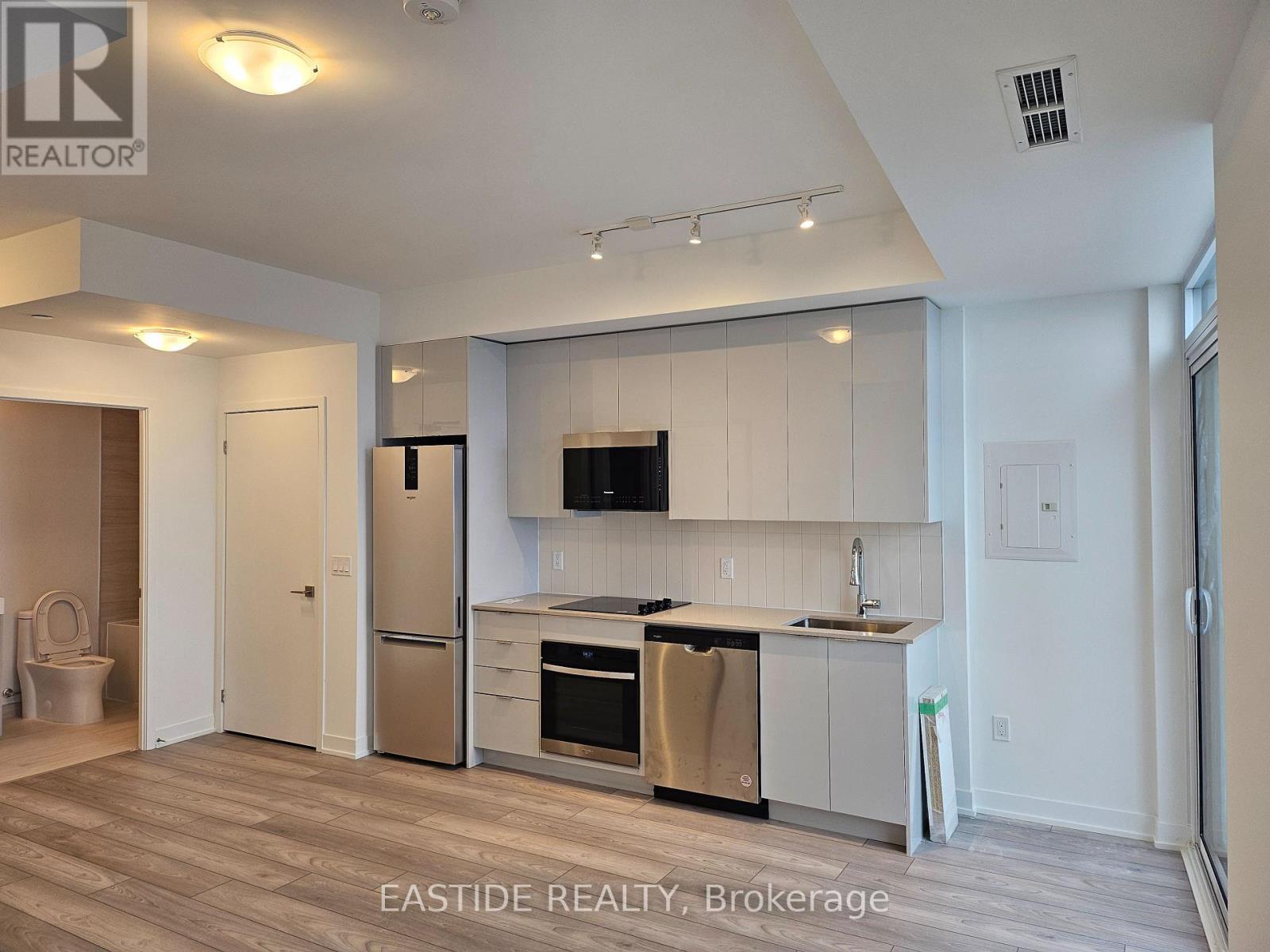 A kitchen with white cabinets and a black stove top oven.