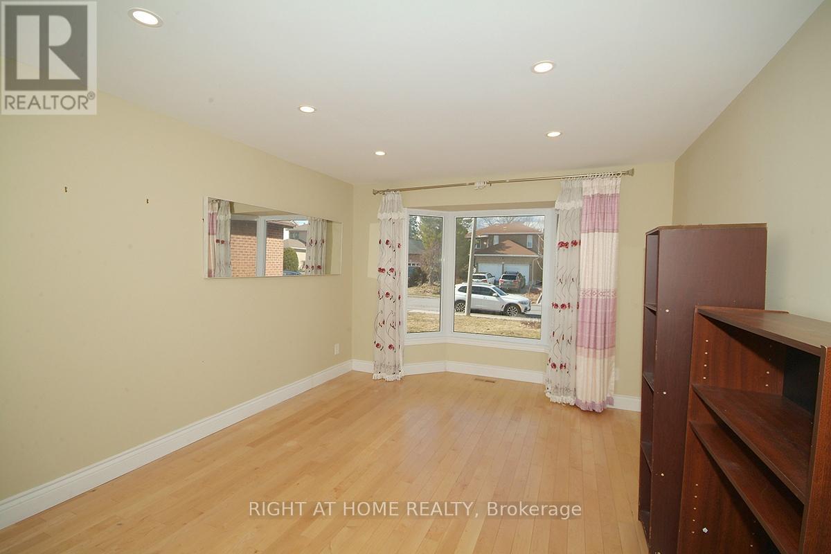 A room with a wooden floor and a window with curtains.