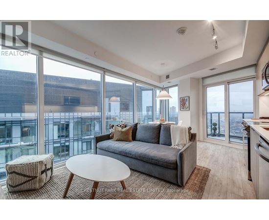A living room with a grey couch and a round table.