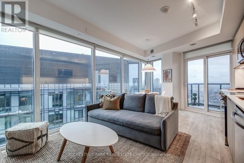 A living room with a grey couch and a round table.
