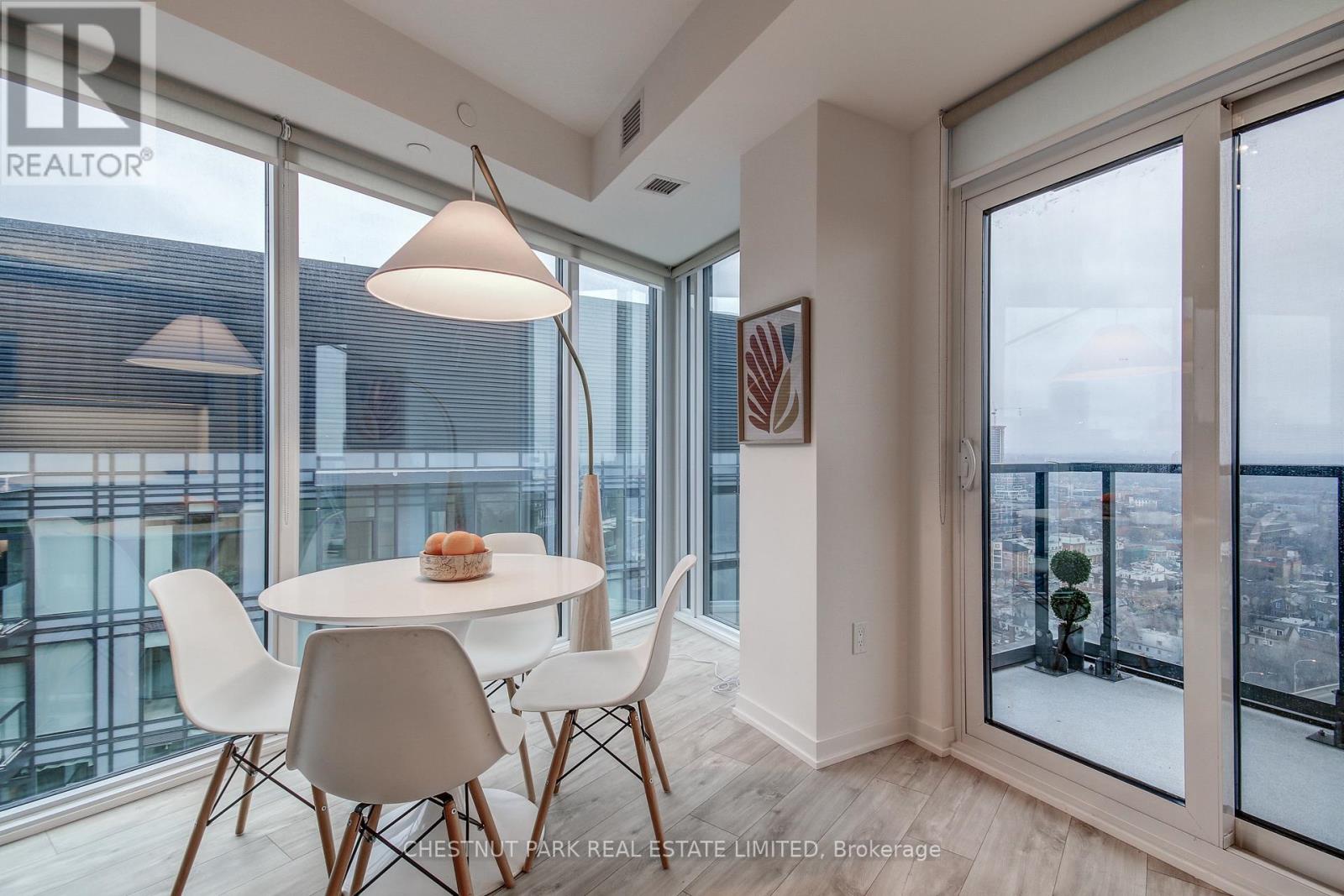 A dining room with a table and chairs and a view of the city.