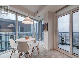 A dining room with a table and chairs and a view of the city.