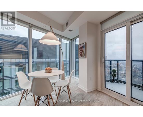 A dining room with a table and chairs and a view of the city.