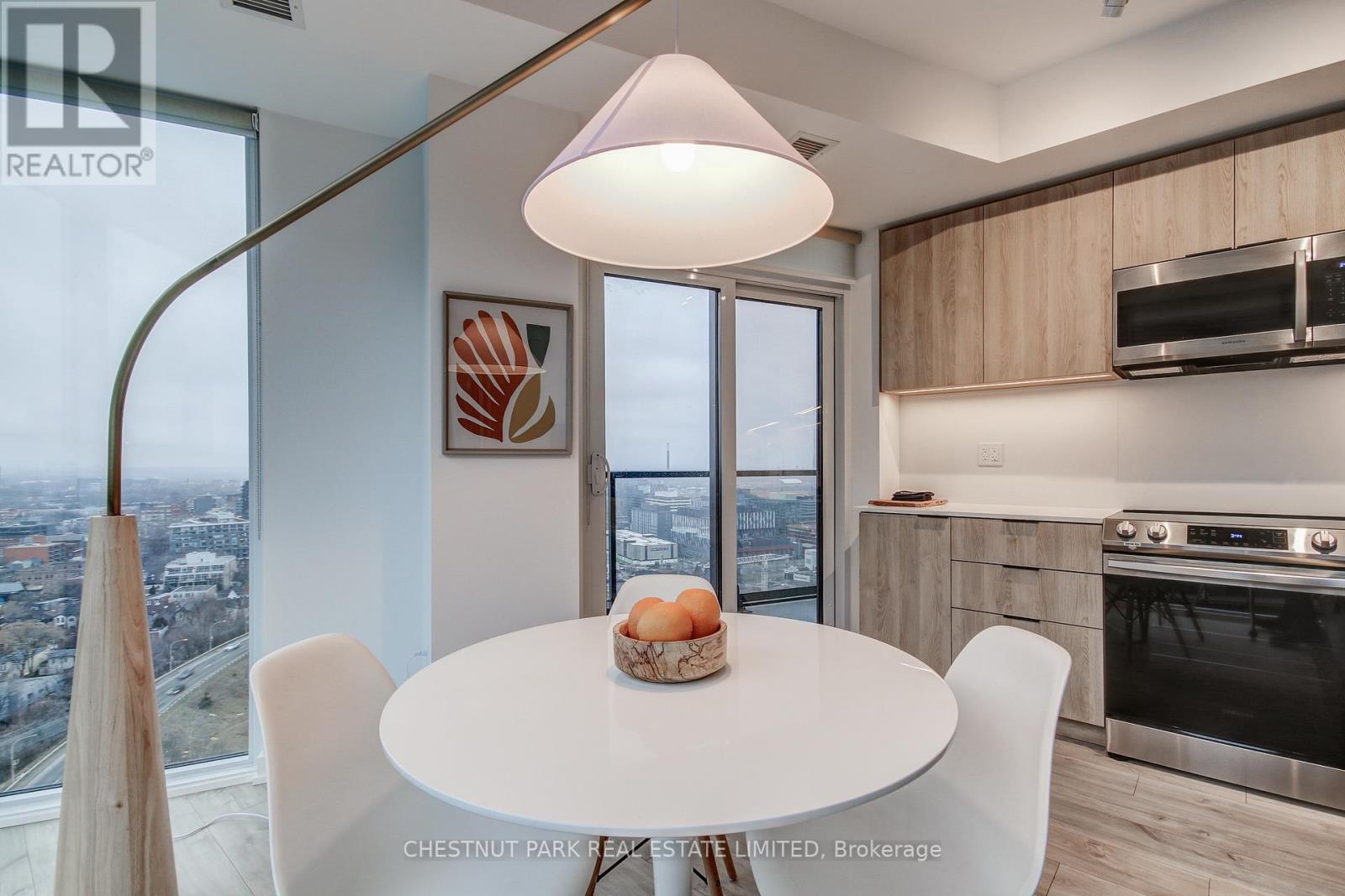 A modern kitchen with a table set for two and a view of the city.
