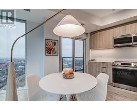 A modern kitchen with a table set for two and a view of the city.