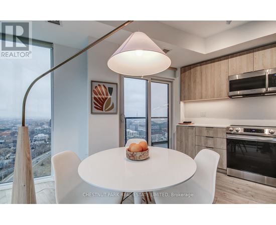 A modern kitchen with a table set for two and a view of the city.