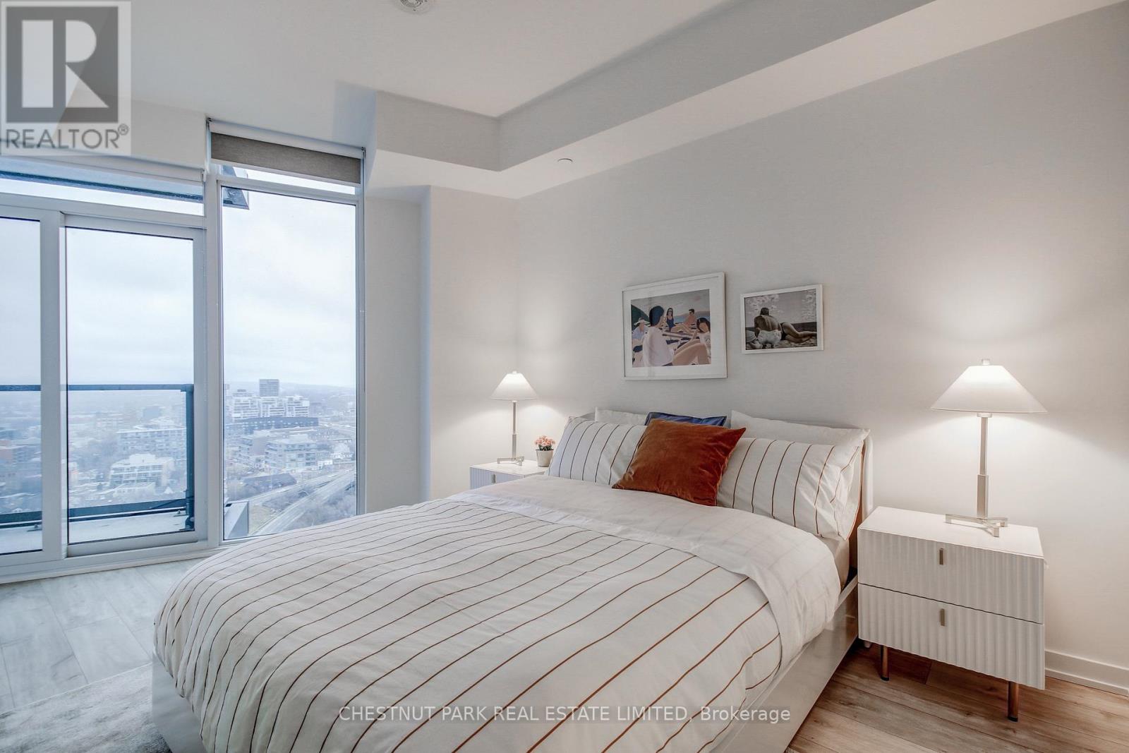 A bedroom with a large bed and a view of the city.