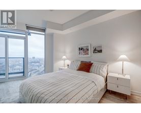A bedroom with a large bed and a view of the city.