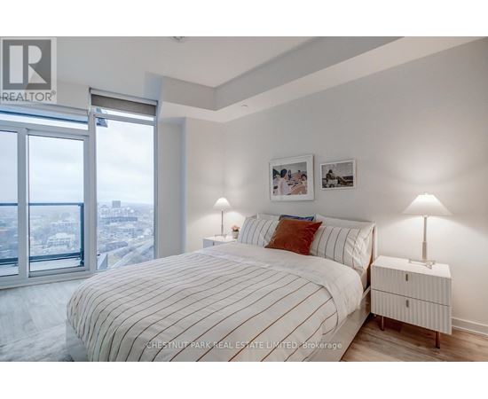 A bedroom with a large bed and a view of the city.