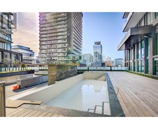 A rooftop pool area with a cityscape in the background.