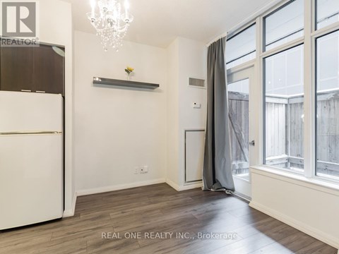 A well-lit, spacious kitchen with a white refrigerator and a chandelier.