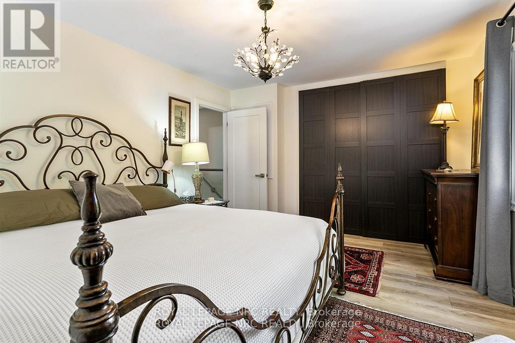 A bedroom with a large bed and a chandelier.