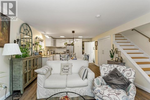 A living room with a white couch and a wooden cabinet.