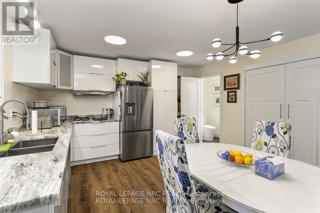 A kitchen with a white counter top and a refrigerator.