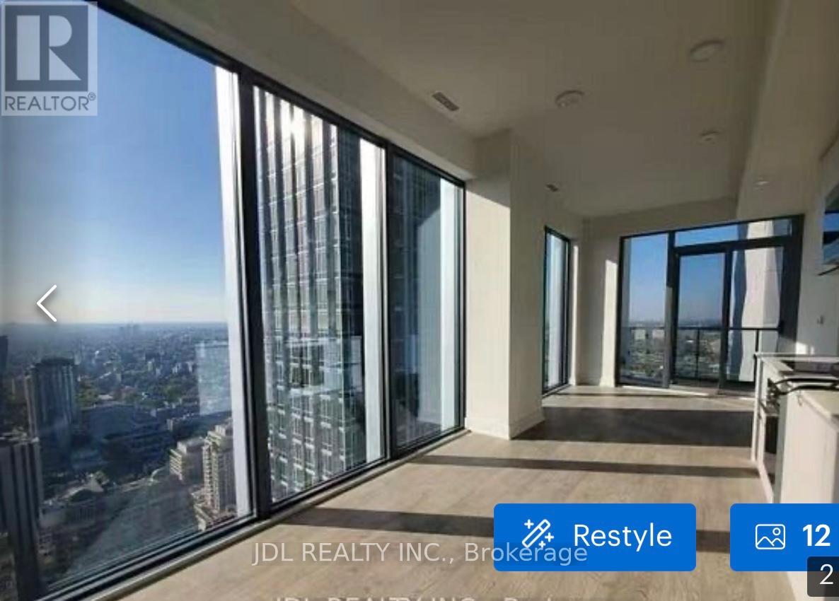 A real estate listing image featuring a large window with a city view.