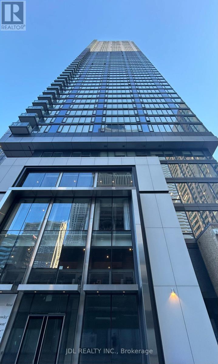 A tall building with a glass facade and a sign that reads "JDL REALTY INC. Brokerage".