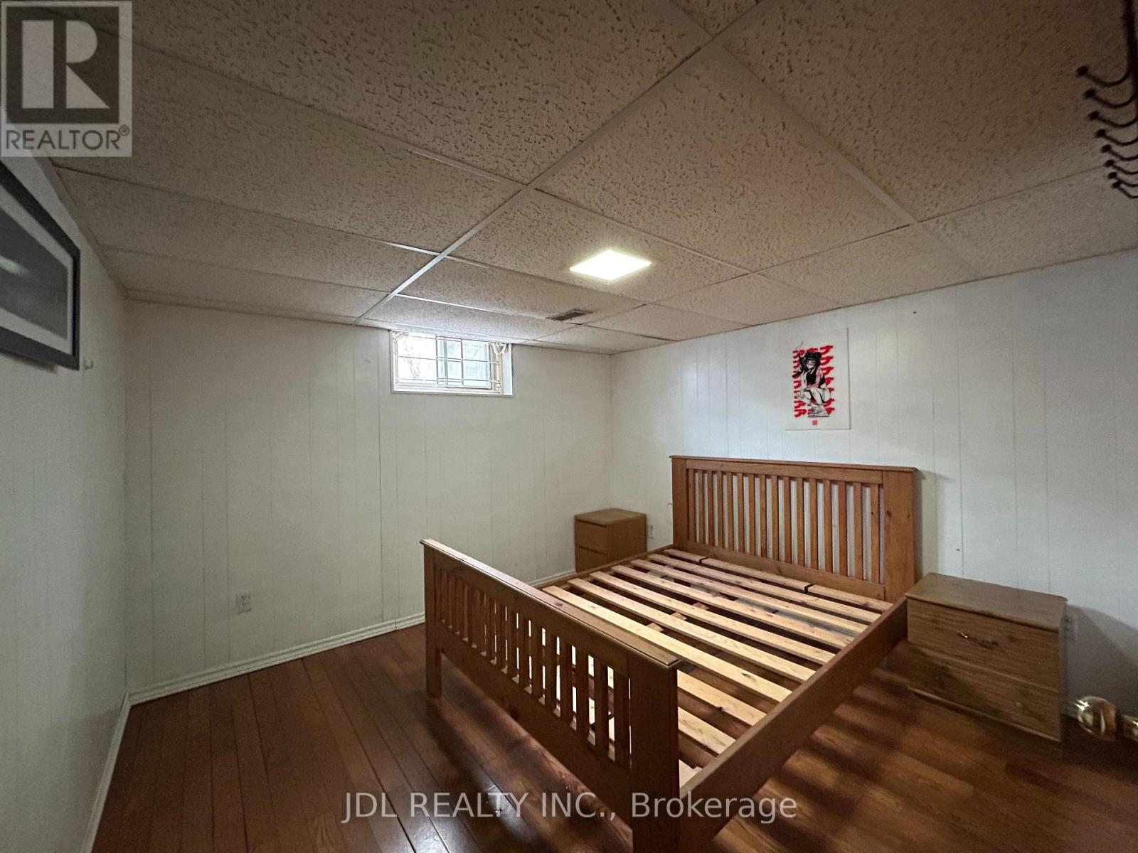 A bedroom with a bed, nightstand, and window.