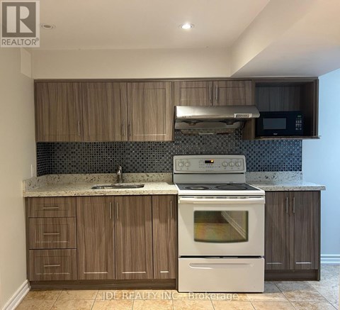 A kitchen with a white oven and wooden cabinets.