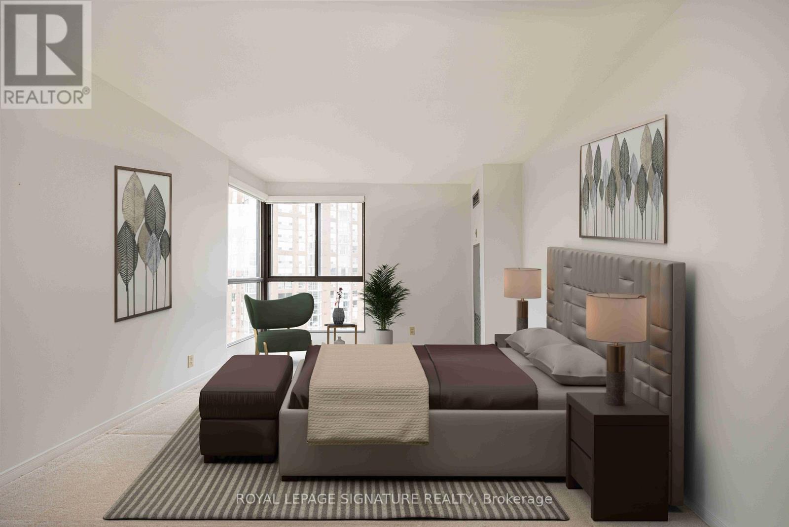 A bedroom with a large bed and a green chair.