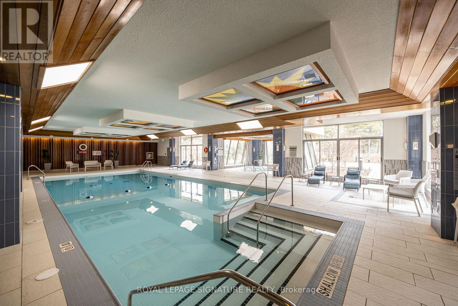 A large indoor swimming pool with a glass divider in the middle.
