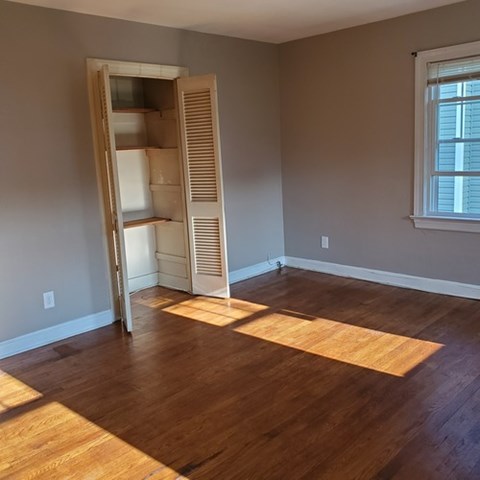 A room with a wooden floor and a white closet.