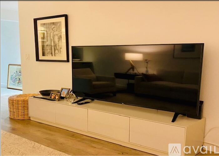 A black television sits on a white cabinet in a living room.