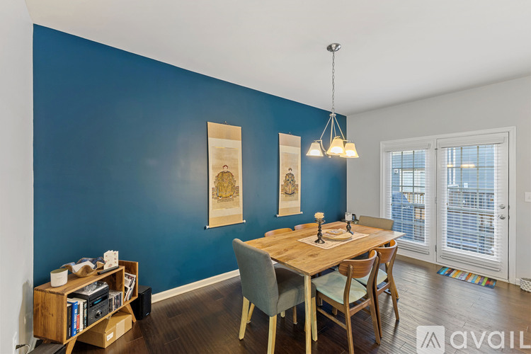 A dining room with a wooden table and chairs.
