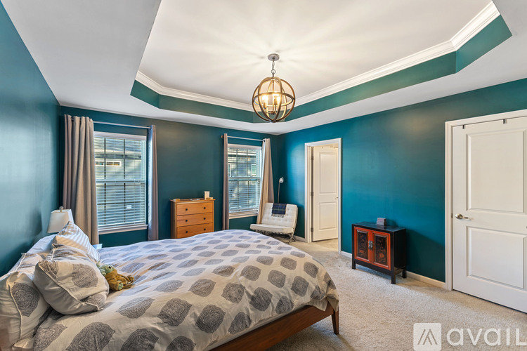 A bedroom with a large bed and a chandelier.