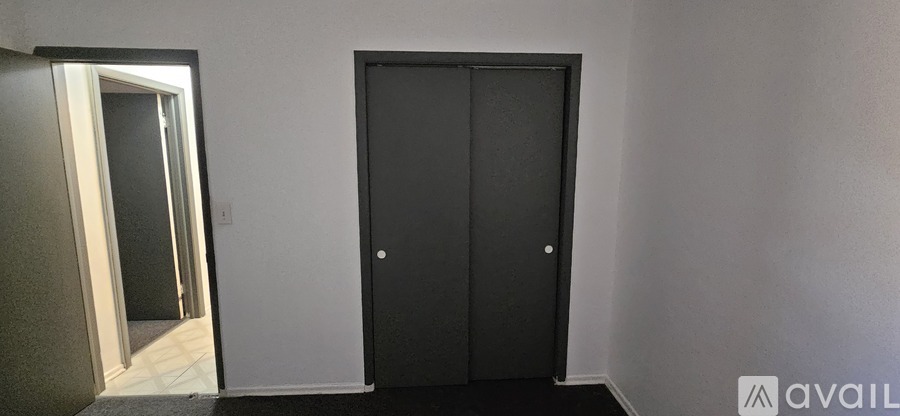 A black door is in a room with a white wall.