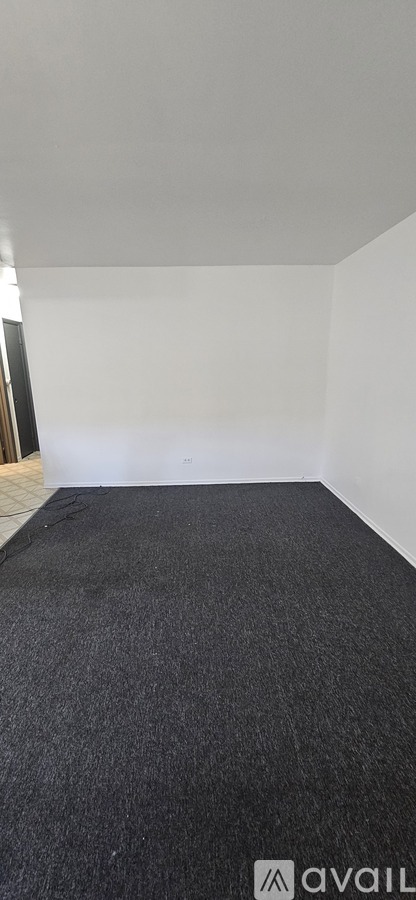 A room with a carpeted floor and white walls.